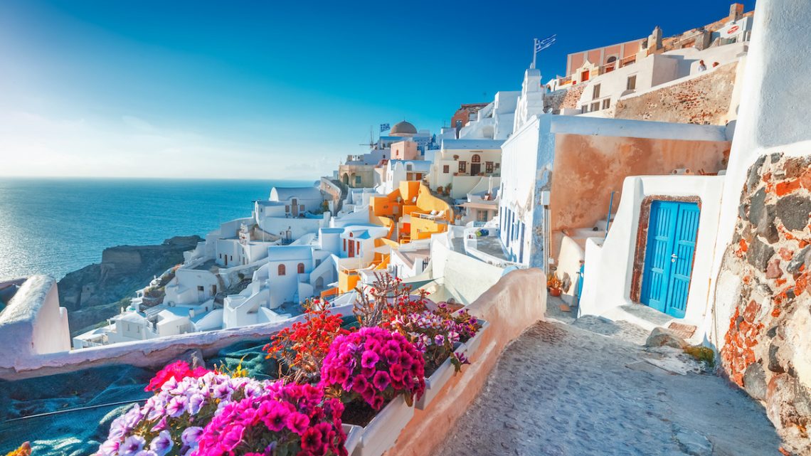 View of white buildings and bright flowers in Santorini, Greece